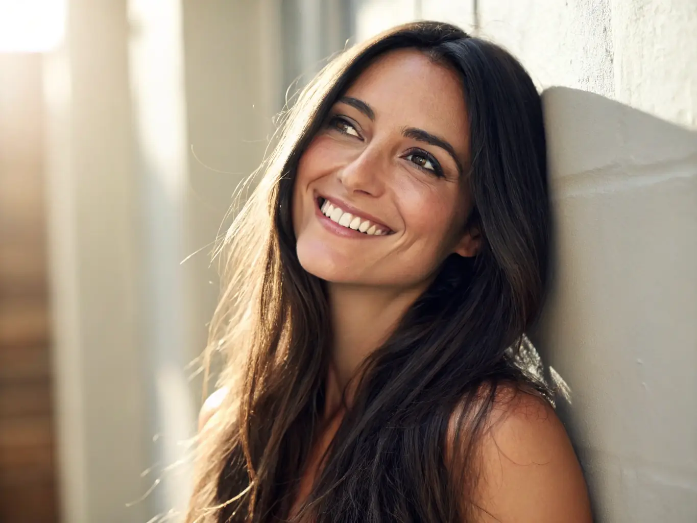 An image of a woman smiling, showcasing her shiny, healthy-looking hair after a keratin treatment. The focus is on the hair's radiant shine and smooth texture.
